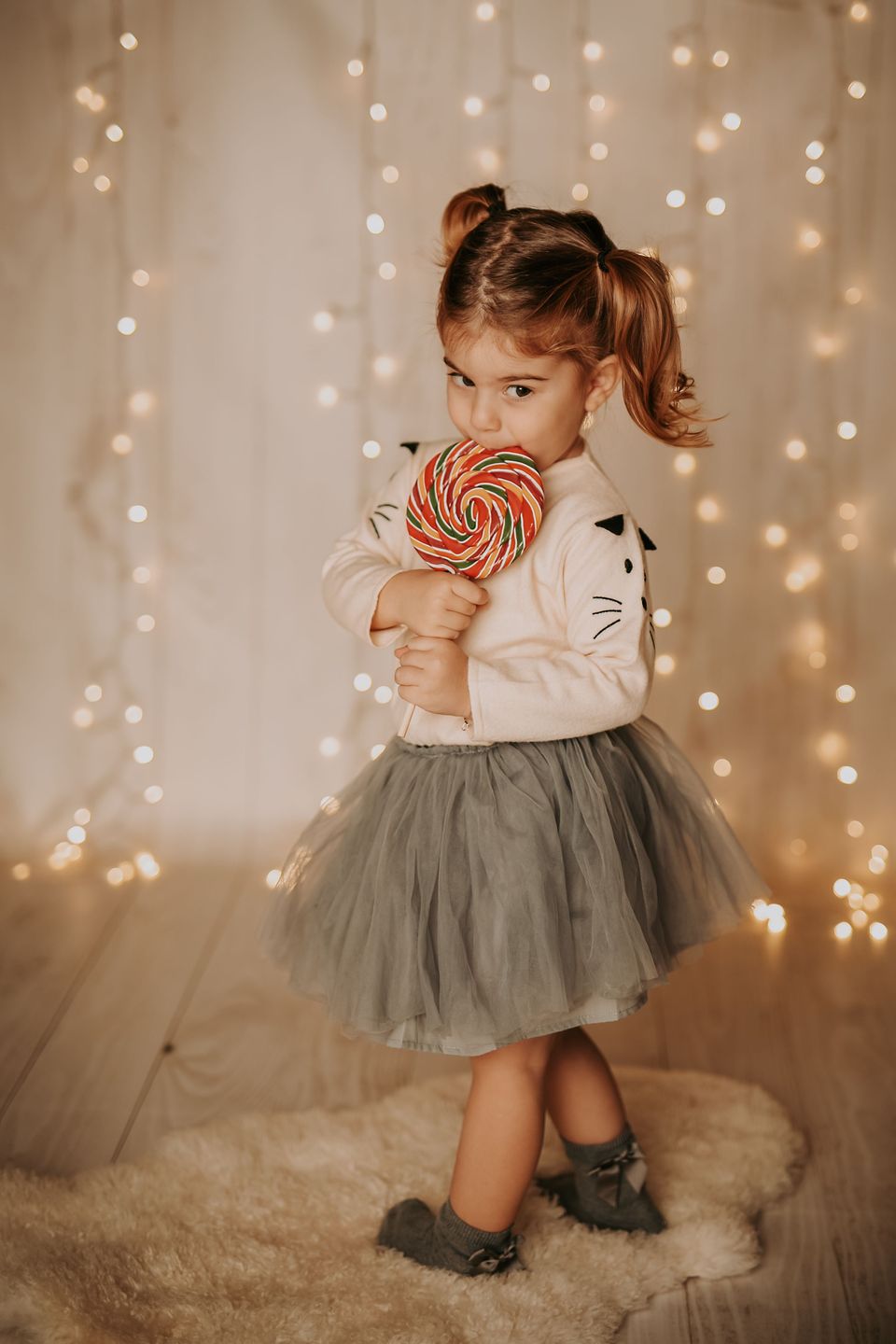 Bambina con il lecca-lecca davanti alle luci