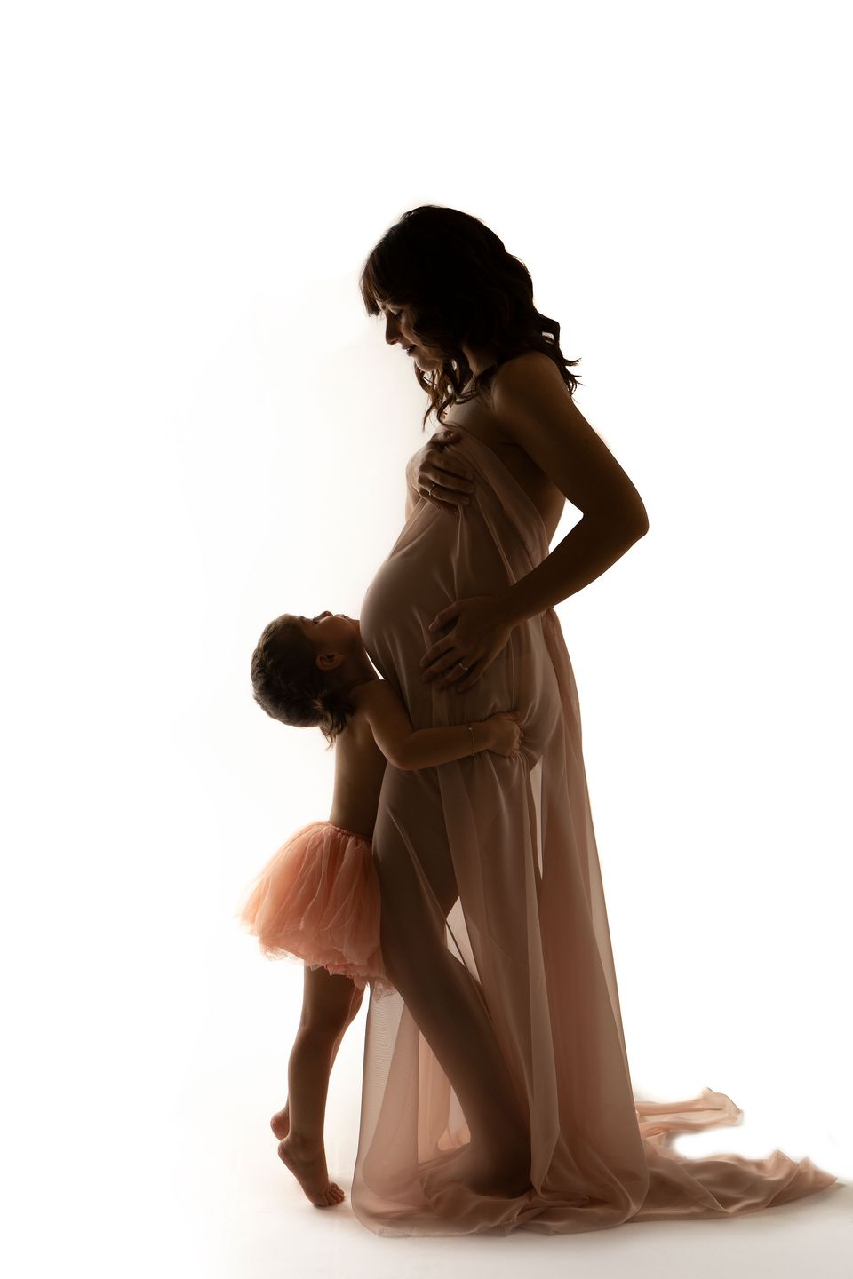 Mamma in attesa e la bambina che le tocca il pancione