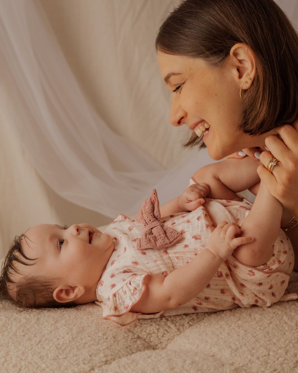 Mamma sdraiata che gioca con la bambina