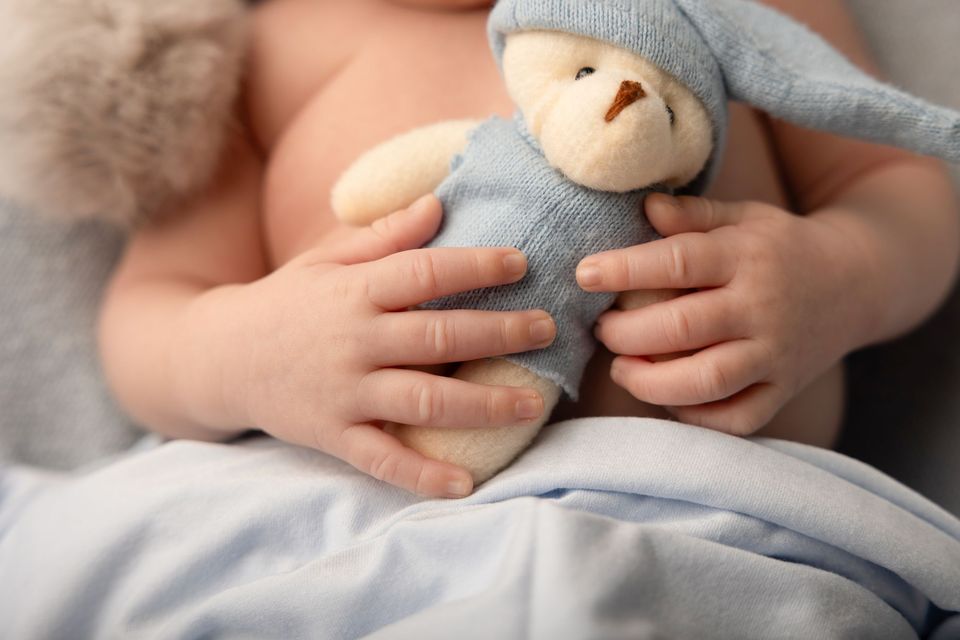 Neonato che stringe un peluche