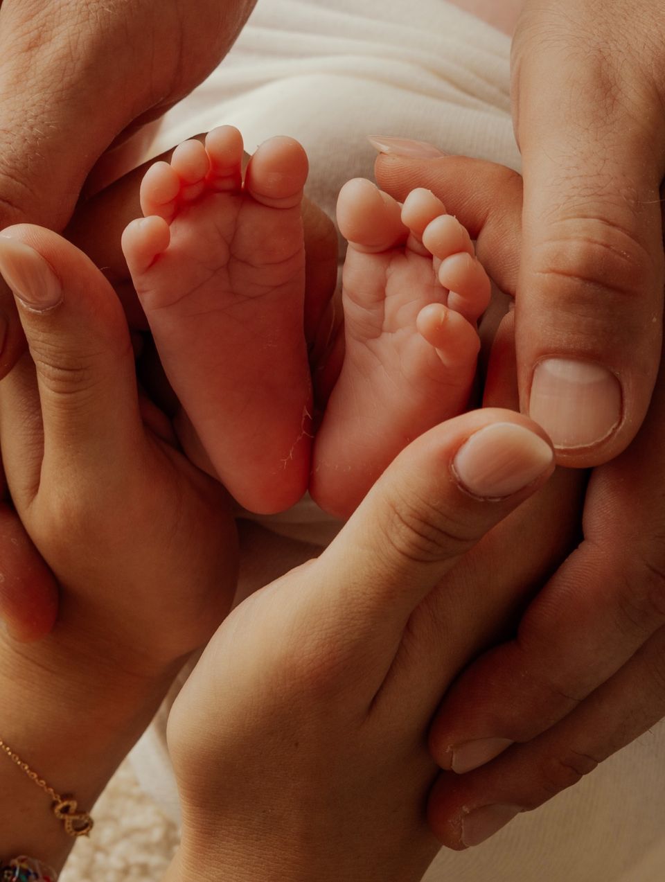 Piedini di un neonato nelle mani dei genitori