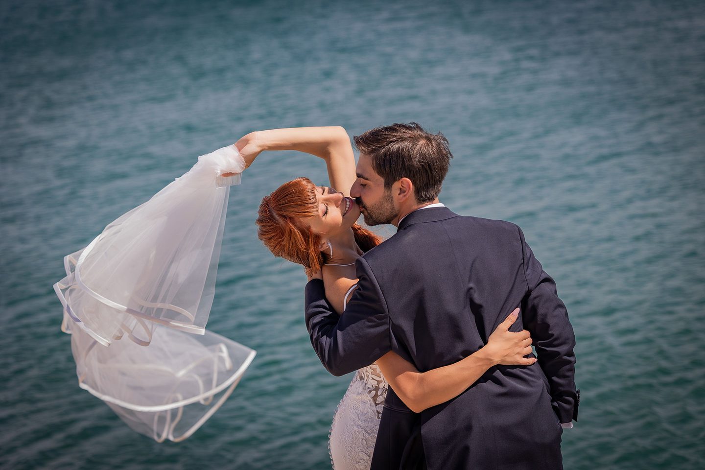 Gli sposi bacio velo mare