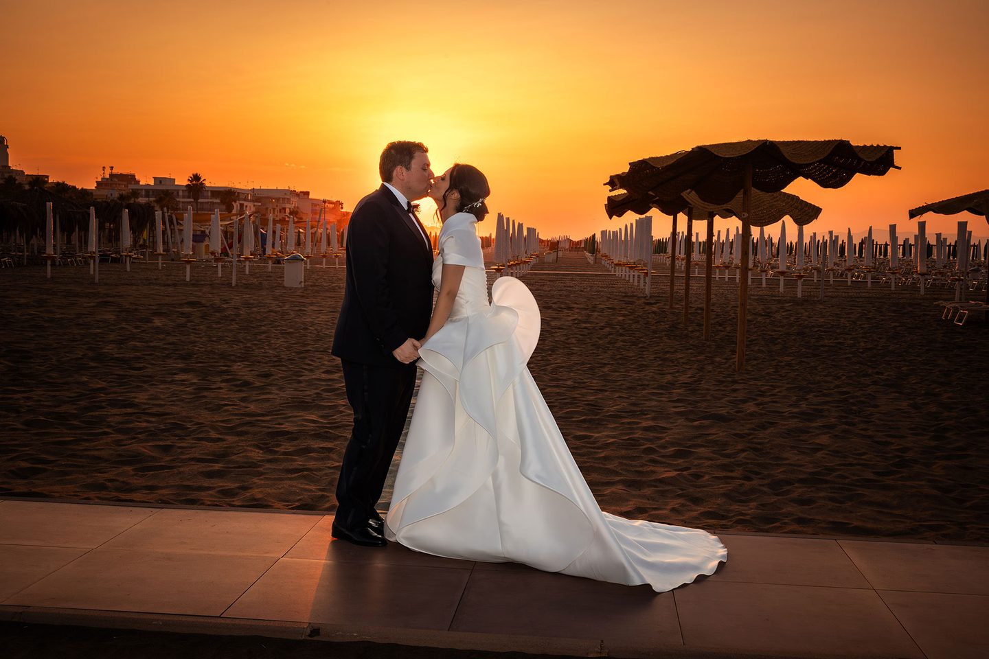 Gli sposi tramonto spiaggia ombrelloni