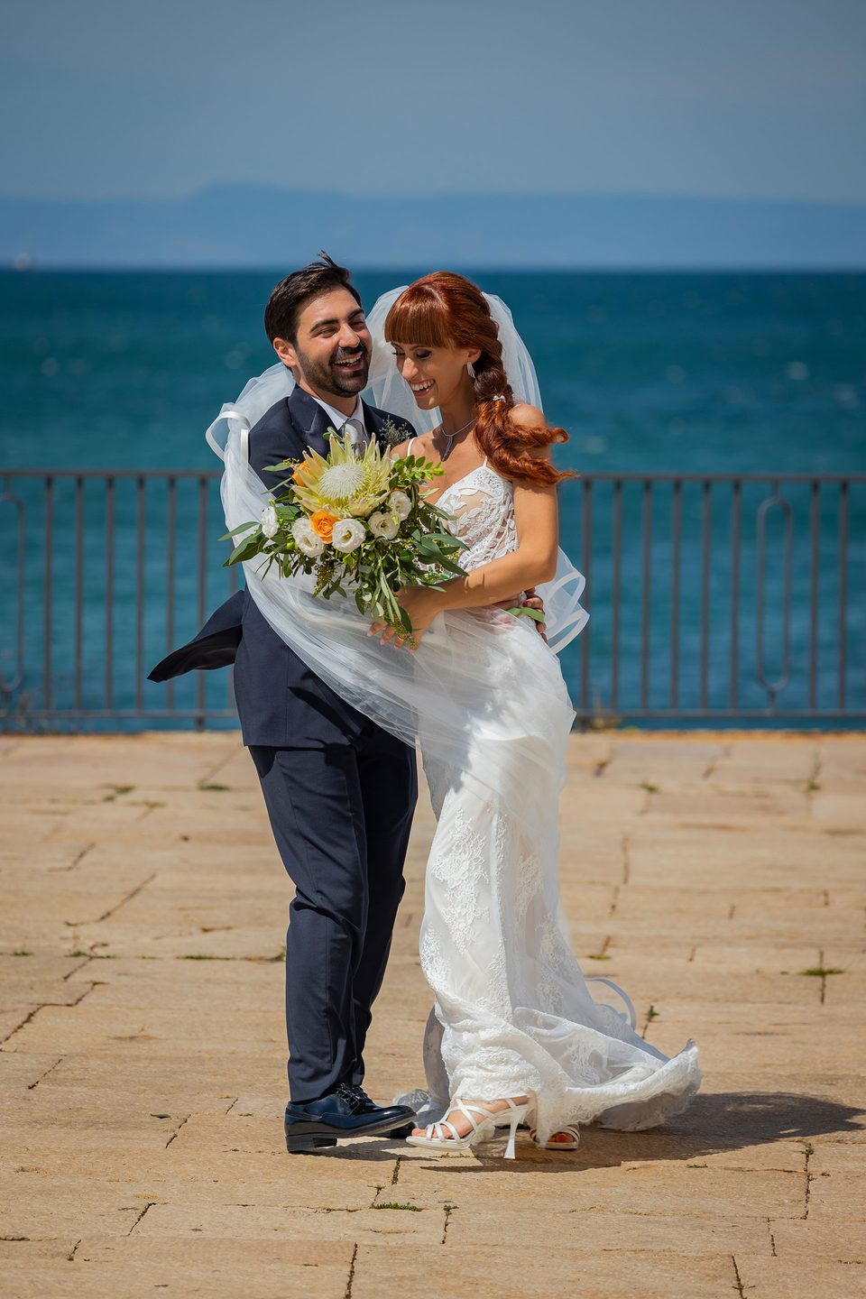 Lo sposo solleva la sposa lungomare